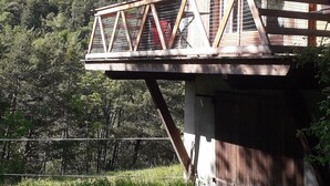 A wooden cabin with a balcony overlooking a forested valley. - CHALETS MONTAGNARD (Jausiers)
