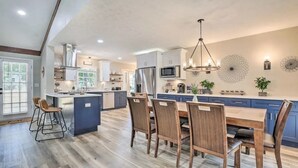 A spacious kitchen with a central island, wooden chairs, and a dining table. - Chic Lilburn Getaway w/Media Room + Fire Pit (Lilburn)