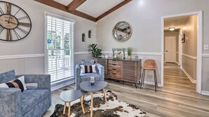 A living room with a sofa, a coffee table, a chair, a sideboard, and a large wall clock. - Chic Lilburn Getaway w/Media Room + Fire Pit (Lilburn)