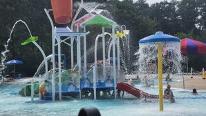 A water park with various water play structures, slides, and a pool area. - Chic Lilburn Getaway w/Media Room + Fire Pit (Lilburn)