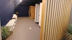 Un pasillo con mostrador de recepción, zona de estar y un separador de madera.
