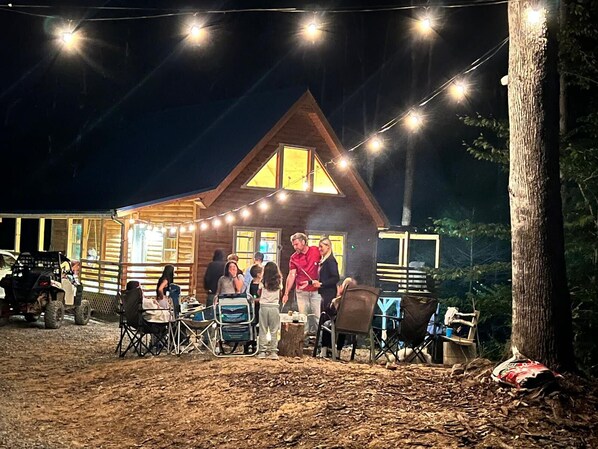 Eine rustikale Holzhütte mit Lichterkette und Erdboden.