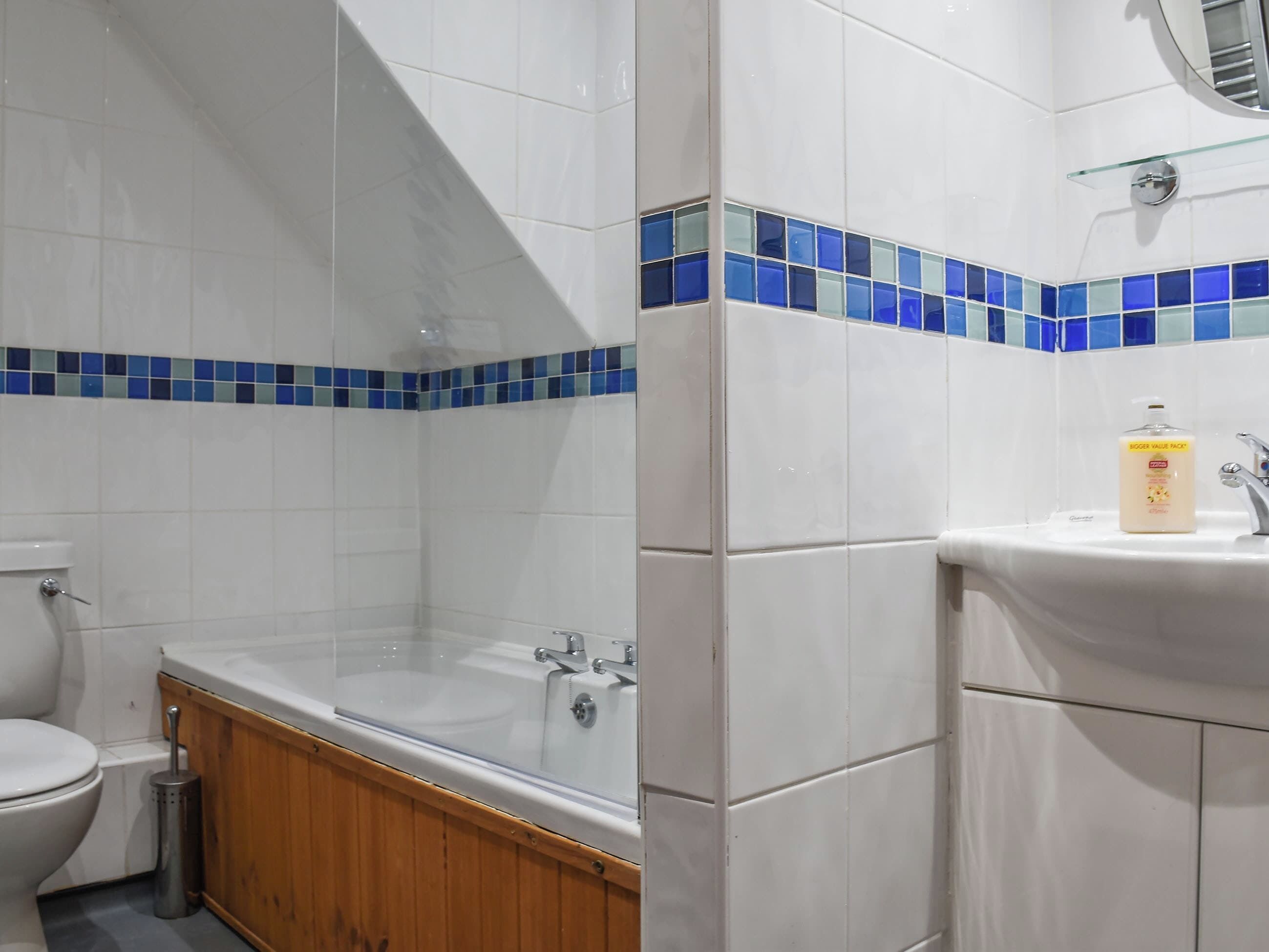 A bathroom with a toilet, bathtub, and sink.