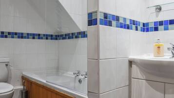 A bathroom with a toilet, bathtub, and sink.