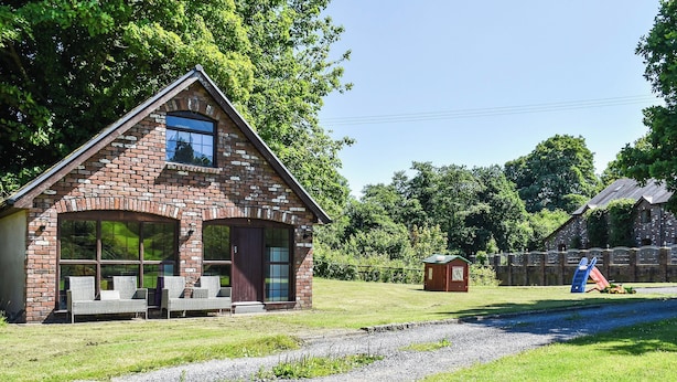 Une maison en briques avec une grande fenêtre et une véranda.
