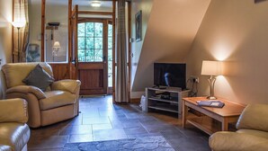 Un salon confortable avec un canapé, un téléviseur et une table en bois.