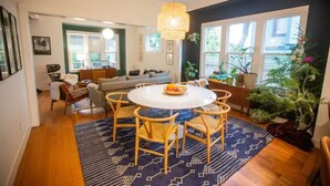 A dining area with a round table, chairs, and a hanging light fixture. - Alberta Arts District 2 private bedrooms/bathroom (Portland)