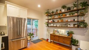 A modern kitchen with stainless steel appliances, wooden cabinets, and a built-in shelf unit for plants. - Alberta Arts District 2 private bedrooms/bathroom (Portland)