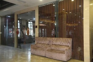 Un vestíbulo con un sofá, una puerta de cristal y una escalera.