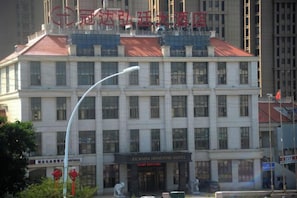 Un edificio de varios pisos con un letrero que dice 'GUANDA HONGTING HOTEL' al nivel de la calle.