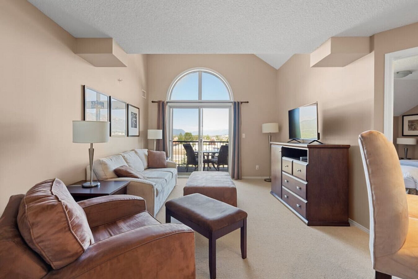 Living room with a smart TV, cozy seating options and a double-sized pull-out sleeper sofa (all bedding provided.)