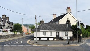 A quiet street with a white house, a bench, and a traffic light. - 2 bedroom accommodation in Llanrwst (Llanrwst)