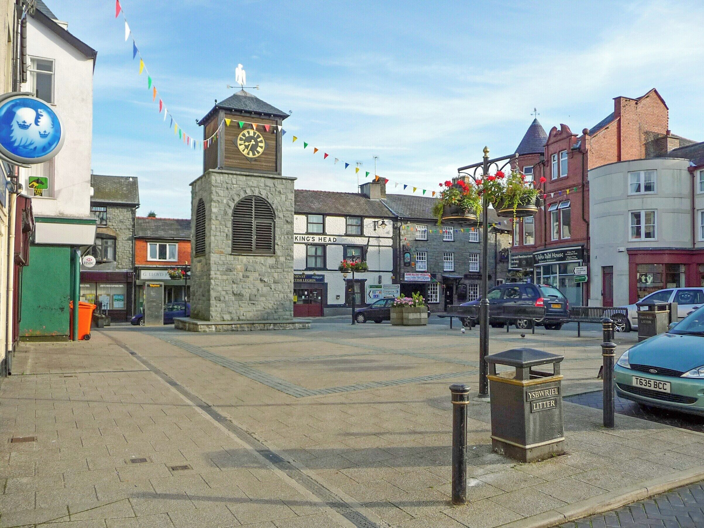 A town square with a clock tower, shops, and a 'King's Head' pub.