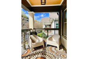 Enjoy the view from this balcony with a window overlooking neighboring buildings.