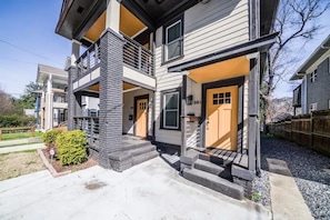 Stylish two-story home with a balcony and well-manicured lawn.