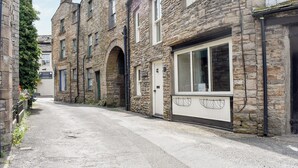 A narrow street with stone buildings, one with a sign for 'Sturmans Antiques'. - 2 bedroom accommodation in Hawes (Hawes)