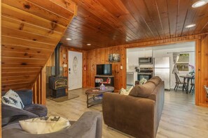 Cozy cabin-style accommodation with a living area, fireplace, and fully equipped kitchen.