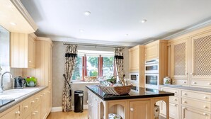 Una cucina moderna con mobili in legno, un'isola centrale e forni integrati.
