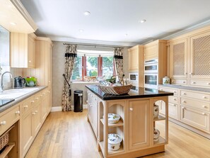 A modern kitchen with wooden cabinets, a central island, and built-in ovens. - 3 bedroom accommodation in Ottringham, near Withernsea (Ottringham, near Withernsea)