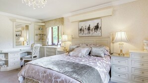 Una camera da letto con un letto grande, una scrivania, una sedia e un lampadario.