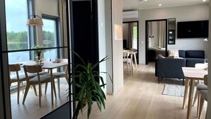 A modern interior with a dining area, a sofa, and a TV.