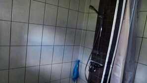 Une salle de bain carrelée avec un espace douche.