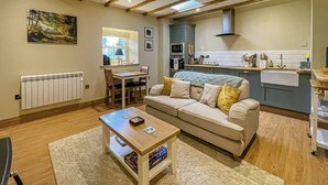 Ein gemütliches Wohnzimmer mit einer Couch, einem Couchtisch und einem Essbereich mit Tisch und Stühlen.