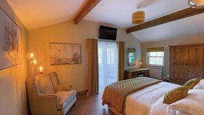 Ein Schlafzimmer mit einem Bett, einem Sessel, einem Schreibtisch und einem großen Fenster.