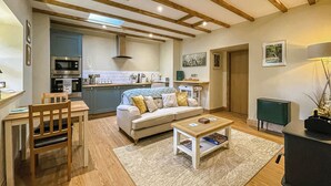 Ein modernes Wohnzimmer mit einer Couch, einem Couchtisch und einem Holzessttisch.