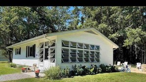 Een gelijkvloers huis met garage, grote ramen en een overdekte veranda.
