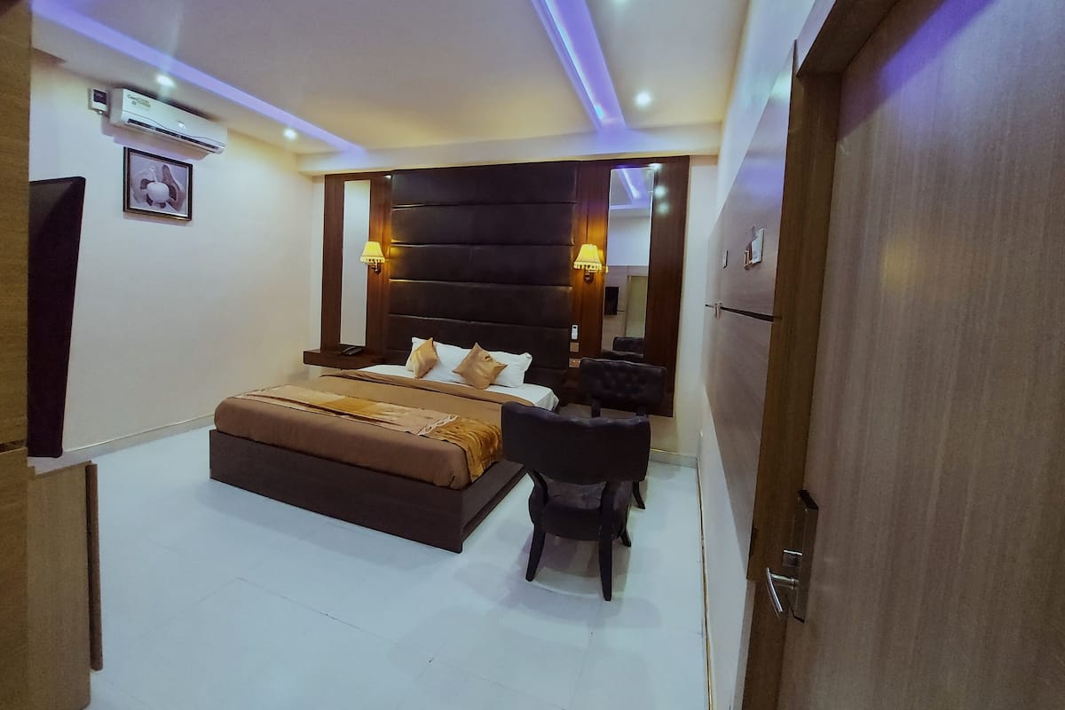 A modern bedroom with a large bed, bedside tables, and a chair.