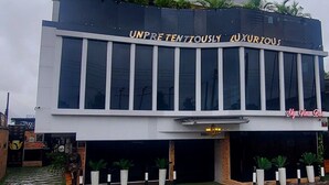 A modern building with the sign "Olympus" and "UNPRETENDENTLY LUXURIOUS" on the facade. - OLYMPUS HOTEL & SUITES (Ibadan)