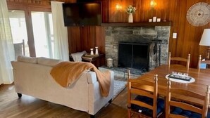 Un salon chaleureux avec une cheminée, des meubles en bois et un téléviseur.