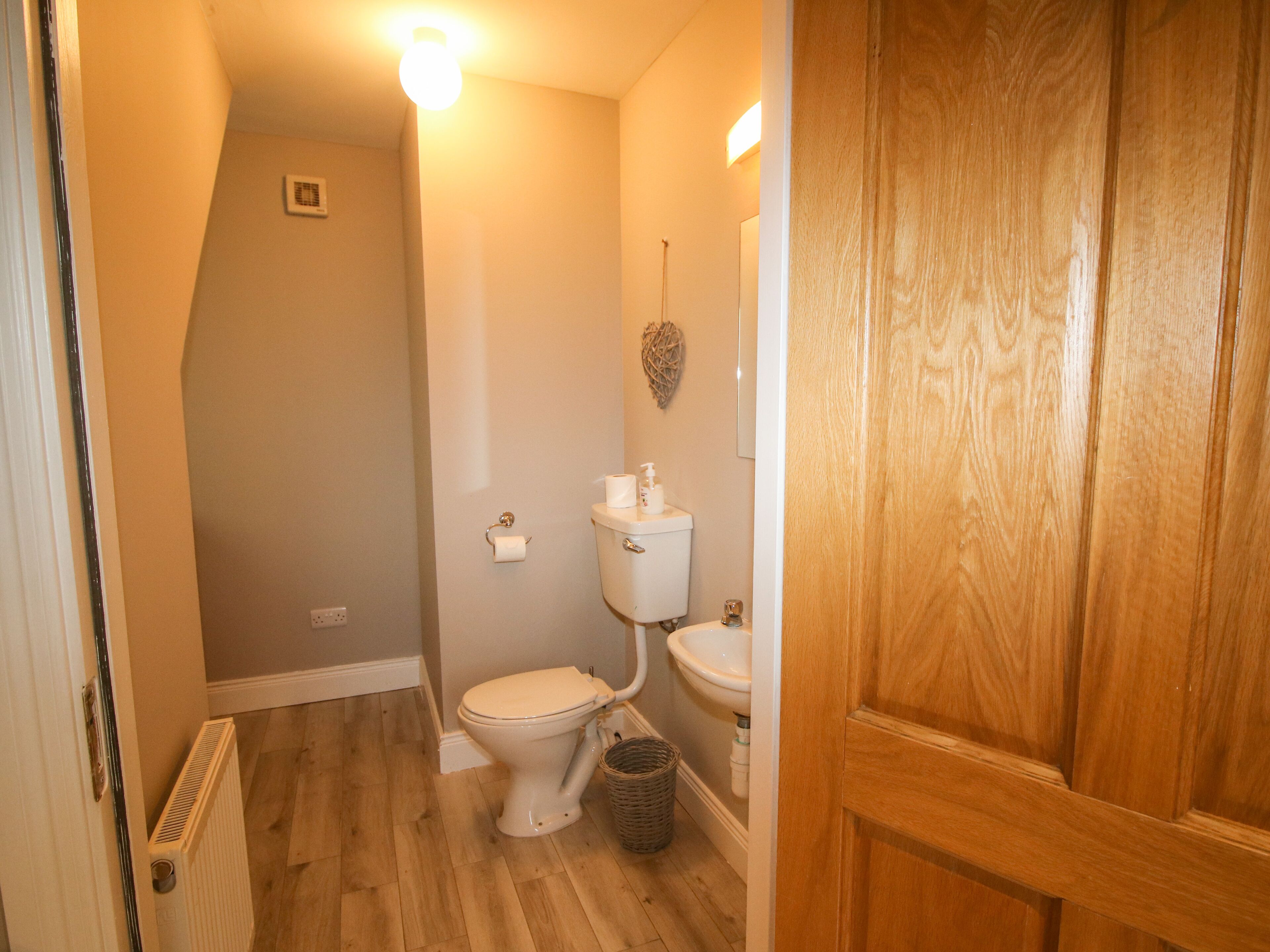 Une petite salle de bain comprenant des toilettes, un lavabo et un radiateur.