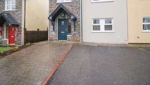 A row of three houses with stone facades and different colored doors. - Pebble Lodge (Kenmare)