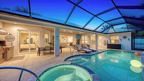 A modern indoor pool area with a glass ceiling, a dining area, and a spa room. - Near Siesta Key | Private Heated Pool & Spa | Palm-Lined Resort-Style Lanai (Sarasota)