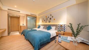 A hotel room with a bed, bedside tables, a desk, and a wall with decorative plates.