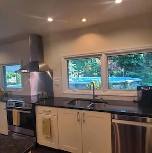 Enjoy cooking in this well-equipped kitchen with a stainless steel range hood, double sink, and oven.