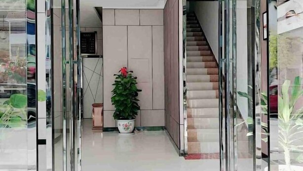 A modern interior with a staircase, a potted plant, and a glass door leading to another room. - Jinjiang Zhixing Hotel (Fengshan)