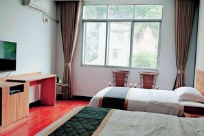 A hotel room with two beds, a desk, a television, and a window with curtains. - Jinjiang Zhixing Hotel (Fengshan)