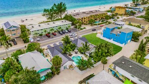 Un hôtel en bord de mer composé de plusieurs bâtiments, doté d’une plage et offrant une vue dégagée sur l’océan.