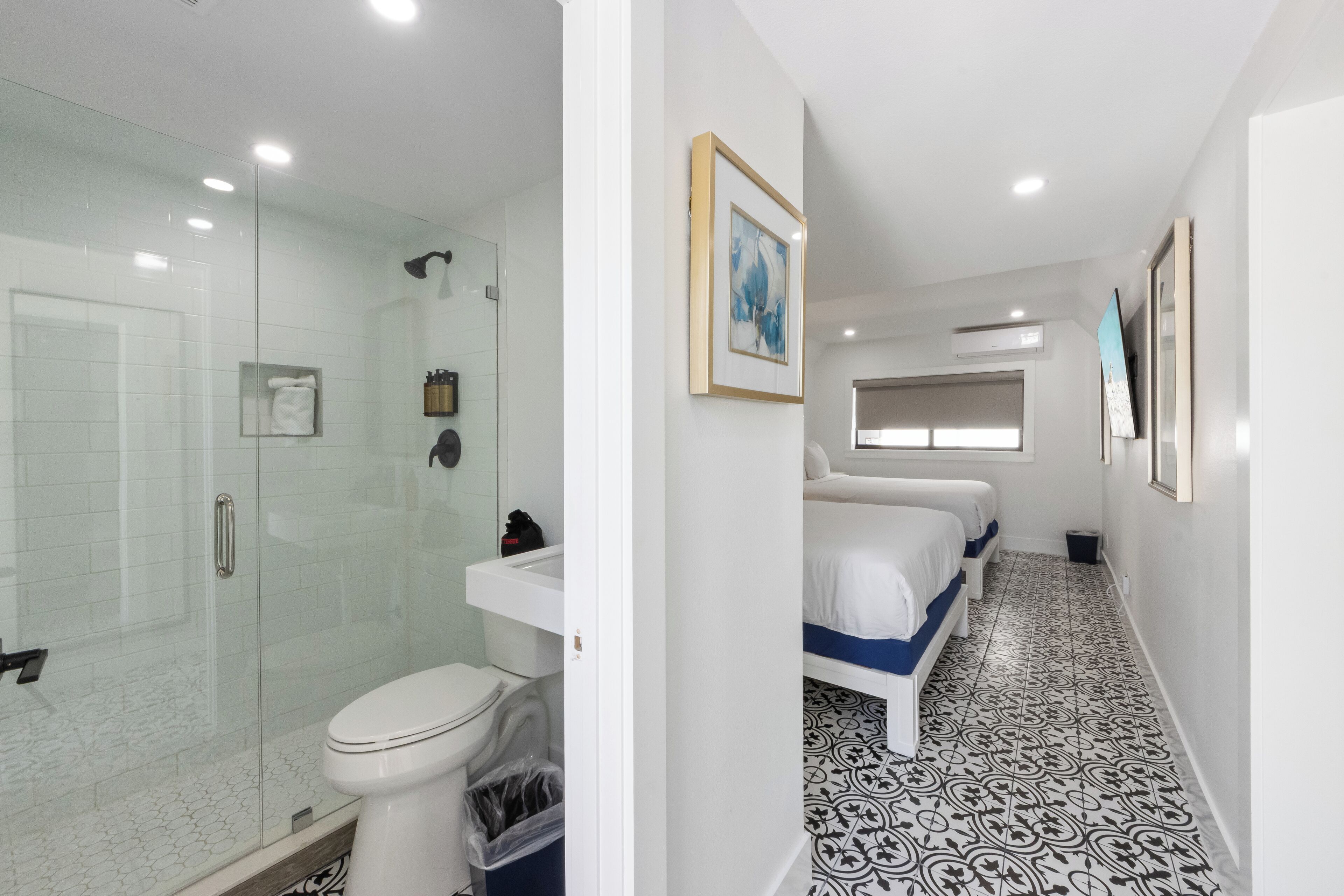 A modern bathroom with a glass shower enclosure, a toilet, and a sink.