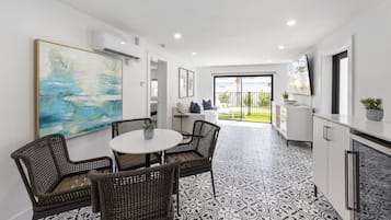 Suite, 2 habitaciones | Área de sala de estar | Televisión de pantalla plana de 55 pulgadas con canales por cable