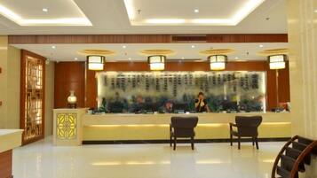 A reception area with a counter, two chairs, and a decorative wall.