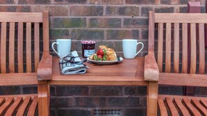 A wooden table with a plate of food, two white cups, and a jar of jam. - 1 bedroom accommodation in Acomb, near York (Acomb, near York)