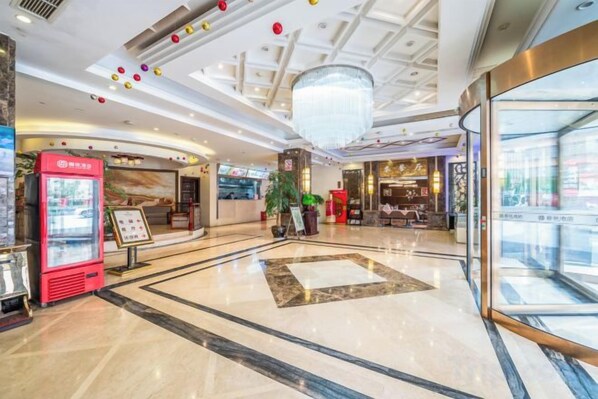 A spacious lobby with a marble floor, a large chandelier, and a glass elevator entrance. - Jia Lian Hotel (Daozhen)
