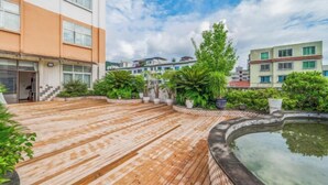 A courtyard with a wooden deck, a swimming pool, and surrounding greenery. - Jia Lian Hotel (Daozhen)