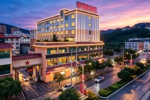 A multi-story hotel with a prominent red sign, multiple floors, and a well-lit facade. - Jia Lian Hotel (Daozhen)
