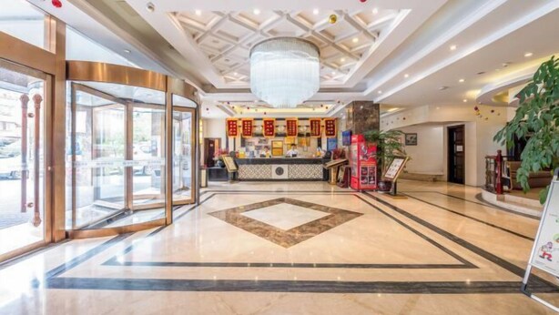 A hotel lobby with a marble floor, a reception desk, and a large chandelier. - Jia Lian Hotel (Daozhen)