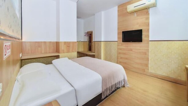 A hotel room with two beds, a mounted TV, and an air conditioning unit. - Duyun Jiayuan Hotel (Duyun)